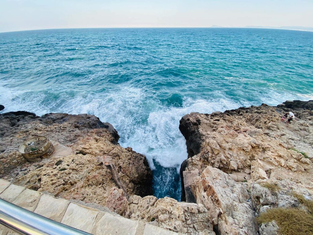 Olas rompiendo contra las rocas junto al mar como metáfora del duelo perinatal, el dolor emocional y el proceso de aprender a volver a respirar tras la pérdida de un bebé.