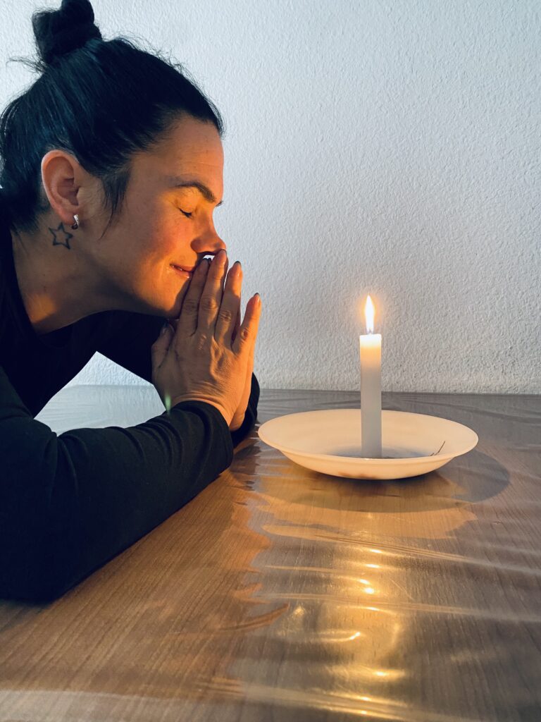 Ritual íntimo de duelo consciente con una vela, símbolo de sanación emocional y amor tras una pérdida