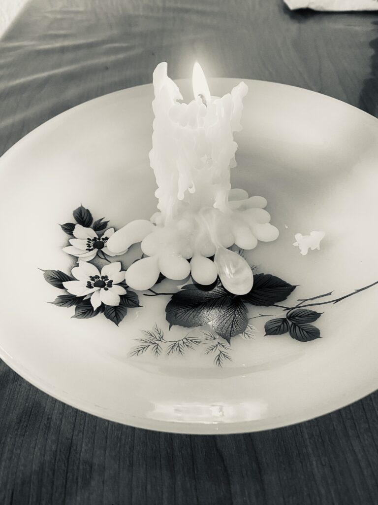 Vela blanca encendida como símbolo de duelo y amor desde otro lugar