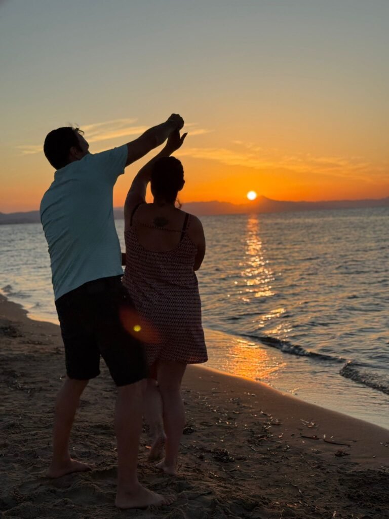 Pareja contemplando el atardecer en la playa, símbolo del amor libre y de la transformación personal tras el duelo perinatal.