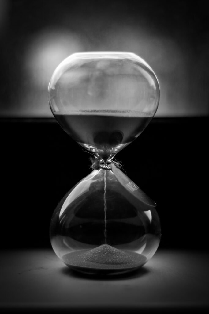 Reloj de arena en blanco y negro con la arena cayendo despacio, como imagen de los tiempos de cada duelo